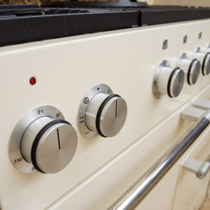 Modern kitchen cooker. Large range style cooker in modern kitchen interior with granite worktop and cream units